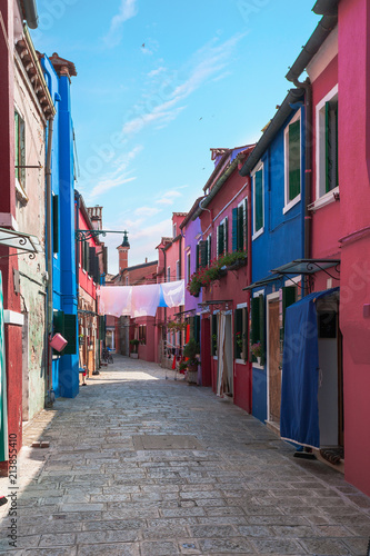 One of the numerous streets of the island of Burano, near Venice with the homeland of colorful houses - the visiting card of the island, Italy