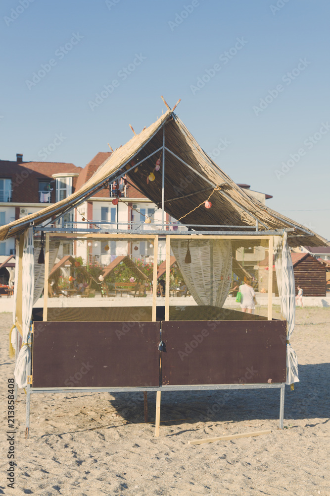 Wooden beach house decorated with sea shells on the beach Wooden beach house decorated with sea shells on the beach