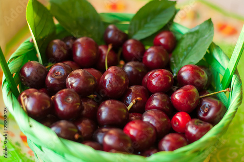Summer mood: a composition of fresh cherries in a wooden basket. Close-up.	