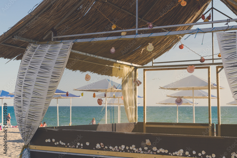Wooden beach house decorated with sea shells on the beach Wooden beach house decorated with sea shells on the beach