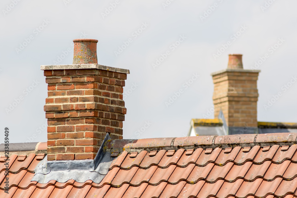 Fototapeta Ceglany komin na nowoczesnym dachu domu