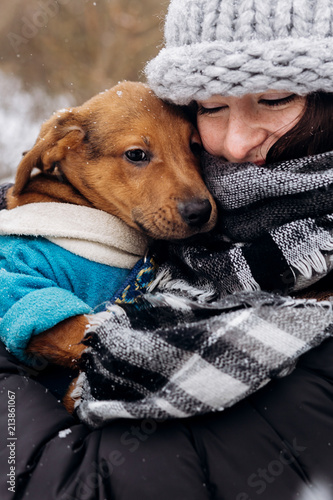 stylish hipster girl hugging and caressing cute puppy in snowy cold winter park. moments of true happiness. adoption concept. save animals © sonyachny