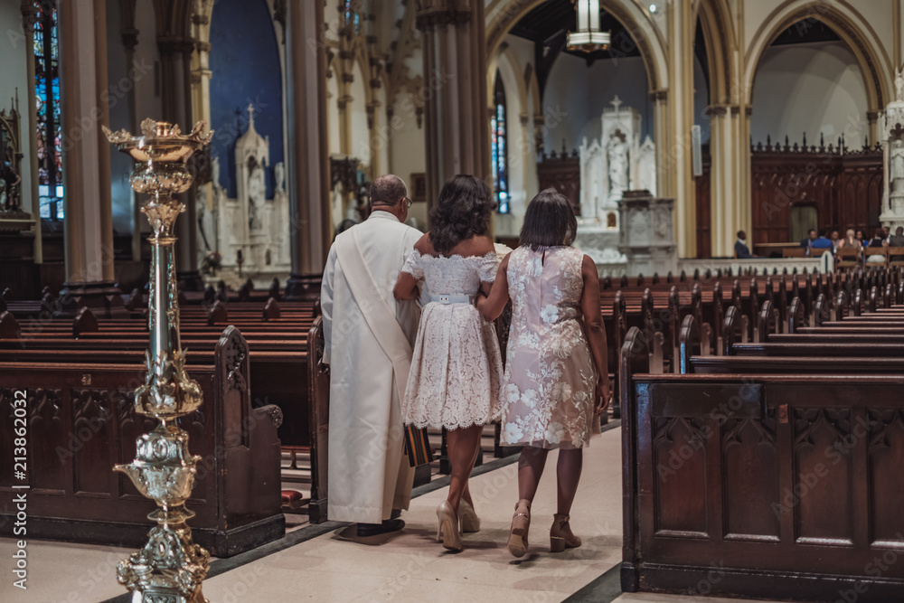 NEW YORK CITY, USA - July 10, 2018: bride with her family going to ceremony in catholic church