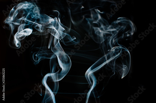 Beautiful white and blue smoke against black backdrop, man and woman shape, motion blur