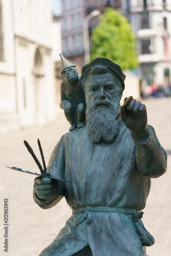 Sculpture of the painter and monkey at the street. The artist Bruegel is depicted at work. He writing the quarter (Marol) in which he lives. photo