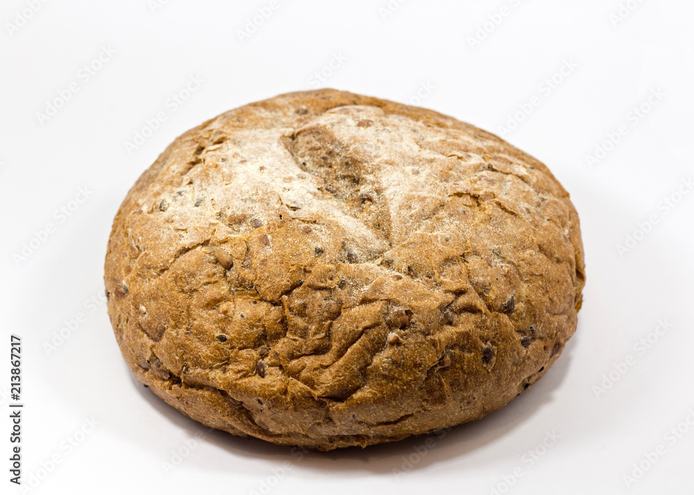One round grain bread isolated on a white background.Whole fresh wheat and rye small bread with a lot of seeds: sunflower, pumpkin, sesame One round grain bread isolated on a white background.Whole fresh wheat and rye small bread with a lot of seeds: sunflower, pumpkin, sesame