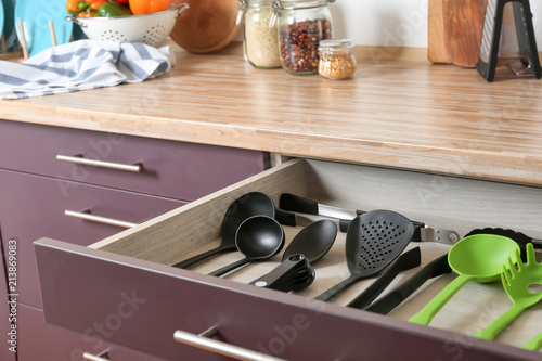 Different utensils for cooking in drawer on kitchen