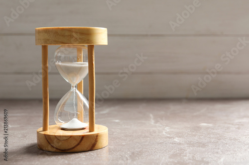 Hourglass with flowing sand on table. Time management