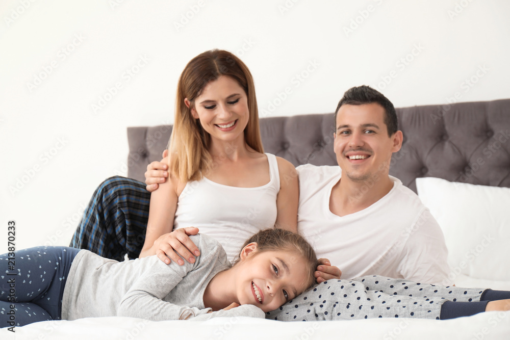 Happy family with cute child in bedroom Happy family with cute child in bedroom