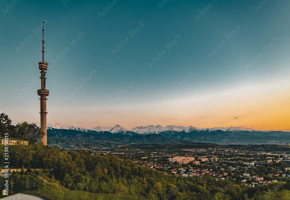 Obraz premium Sunset over the city of Almaty and a view of the Kok Tobe TV Tower