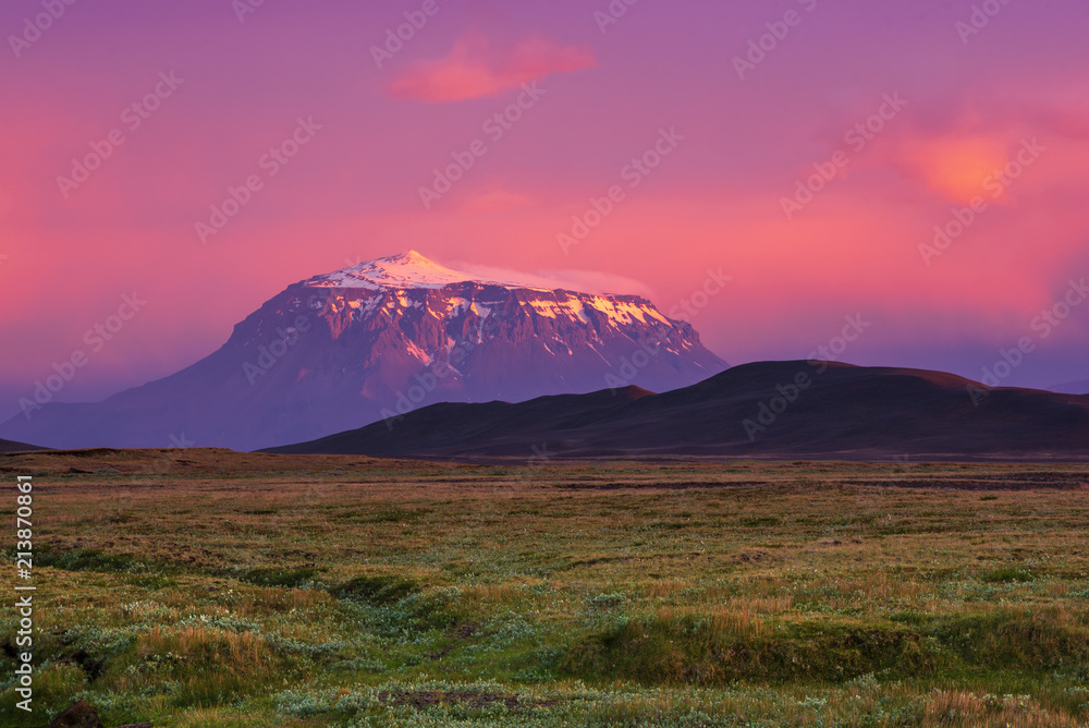 Beautiful volcanic mountain in Iceland covered with snow in pink sunset light