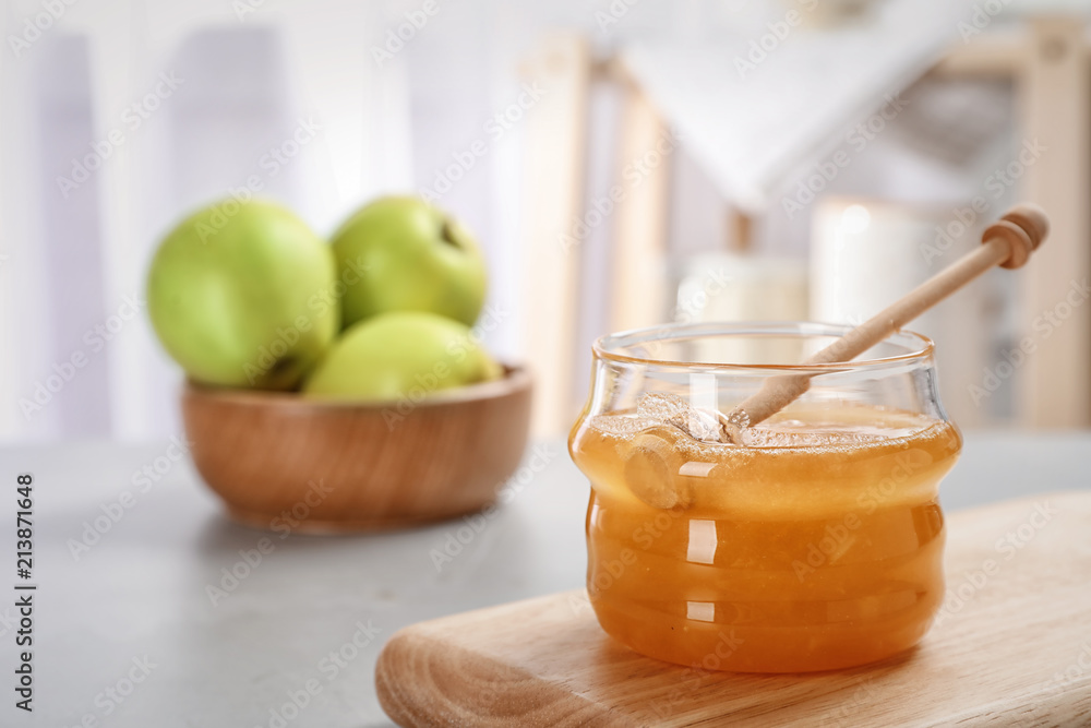 Jar of honey, apples and dipper on light table Jar of honey, apples and dipper on light table
