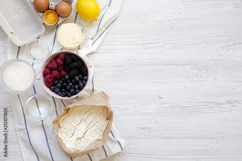 Ingredients for cooking berry pie on white wooden background, top view. Flat lay. Space for text. photo