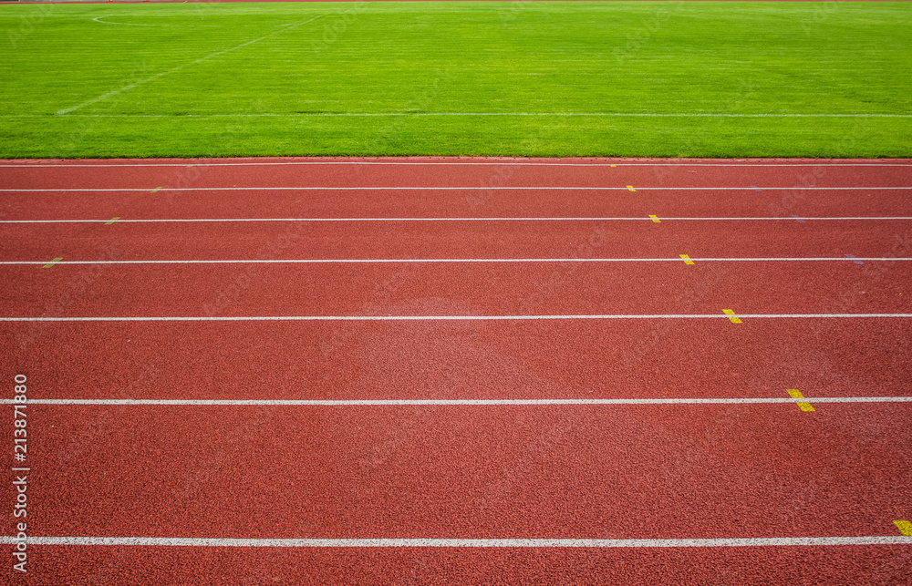 Fototapeta premium red running track background texture with white marking lanes and empty space for copy or text