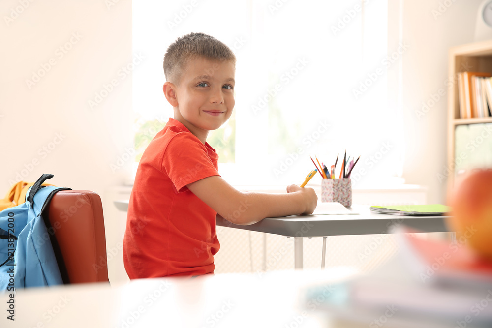 Cute little child sitting at desk in classroom. Elementary school Cute little child sitting at desk in classroom. Elementary school