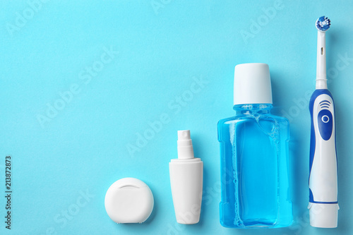 Flat lay composition with electric toothbrush and oral hygiene products on color background