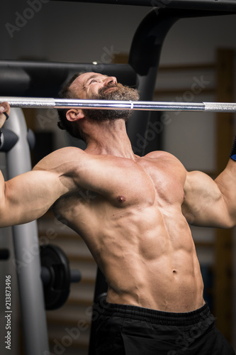 Hombre fuerte con grandes músculos haciendo dominadas en el gimnasio. Ponerse en forma.