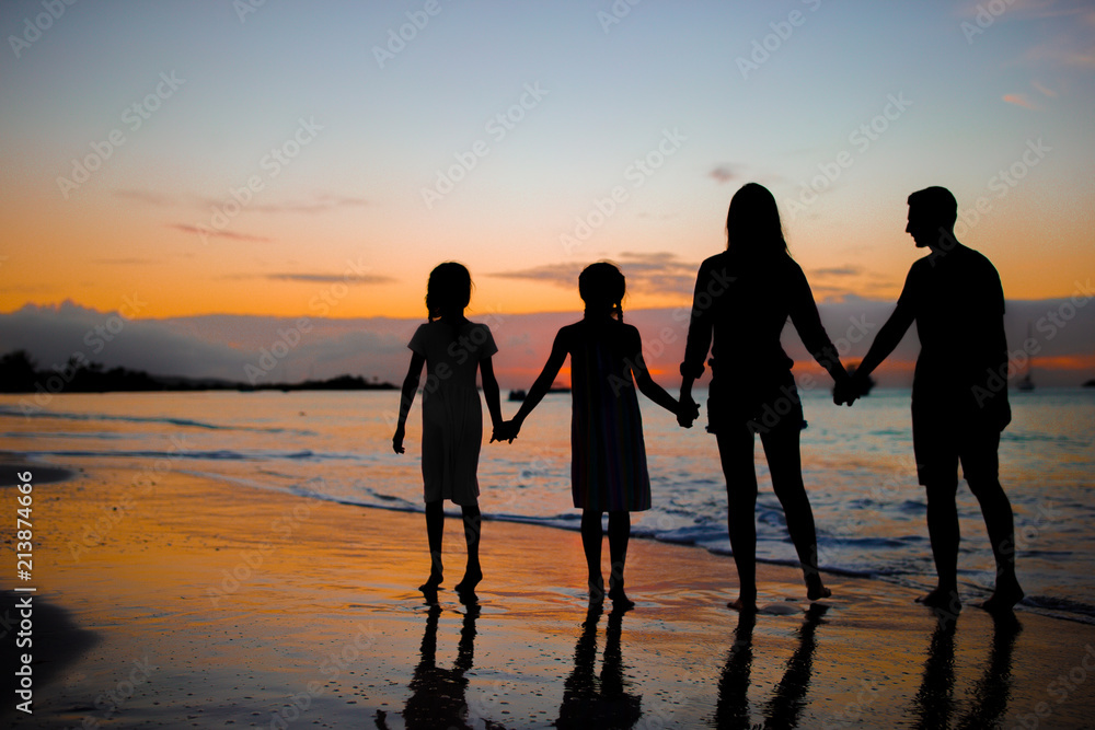 Family silhouette in the sunset at the beach