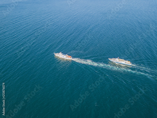 top view of two cruise ships in the open sea, one outrunning another © Mihail