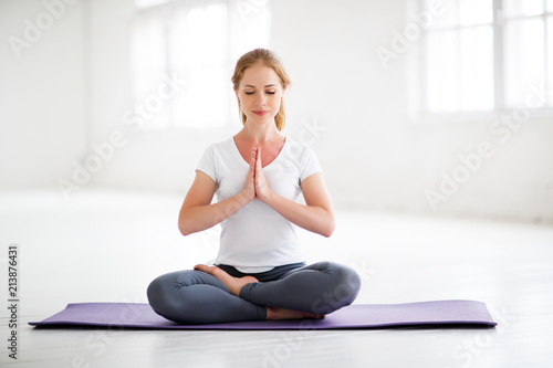 Fototapeta Naklejka Na Ścianę i Meble -  woman practicing yoga and meditating in lotus position