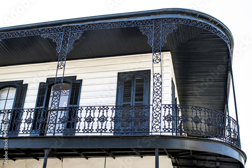 Beautiful Black Wrought Iron Balcony on a Classic White Home with Black Shutters and Detailing in the French Quarter of New Orleans, Louisiana, USA