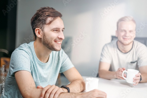 young men in office at meeting during coffee break. modern colleagues in casual clothing T-shirt.