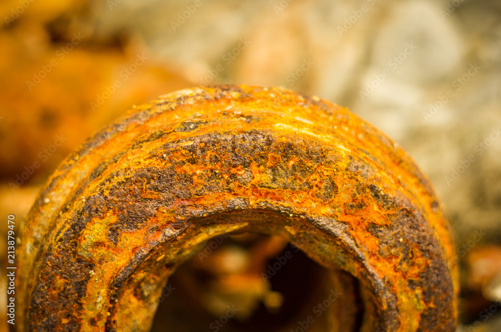 Very rusty metal on a gray cracked rock Very rusty metal on a gray cracked rock