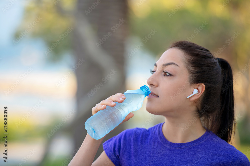 Young girl drinking water during morning jogging Young girl drinking water during morning jogging
