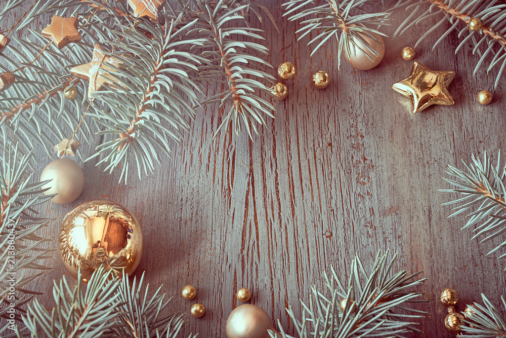 Christmas rustic background on old wood with Xmas tree twigs and golden decorations