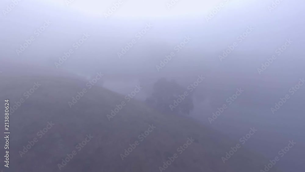 Droning over a peaceful blue reservoir on a foggy morning Droning over a peaceful blue reservoir on a foggy morning