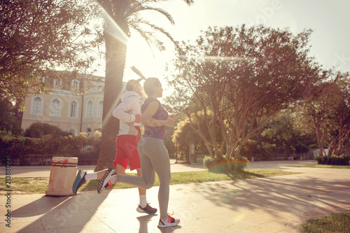 Urban sports, healthy young couple jogging in the city at sunny morning