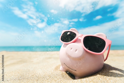 Piggy bank with sunglasses on the beach © BillionPhotos.com