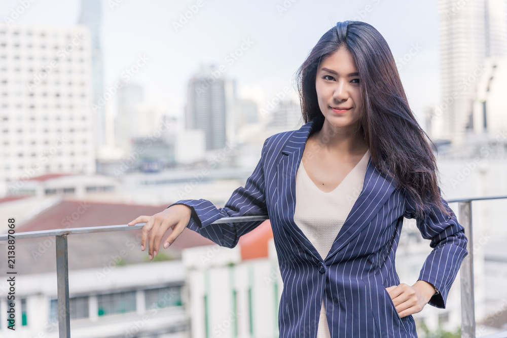 Fototapeta premium Business woman with office building background.