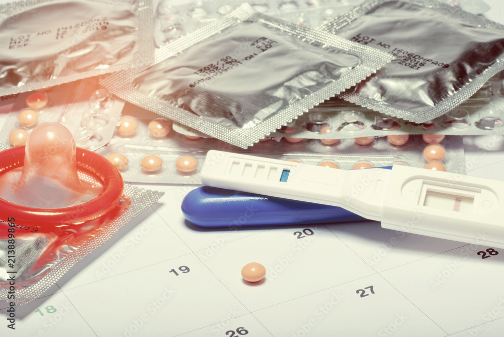 condom with contraceptive on calendar background, close up birth control pill on calendar, health care and medicine concept condom with contraceptive on calendar background, close up birth control pill on calendar, health care and medicine concept