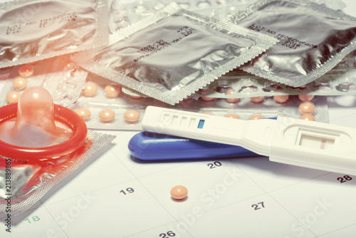 condom with contraceptive on calendar background, close up birth control pill on calendar, health care and medicine concept © waranyu
