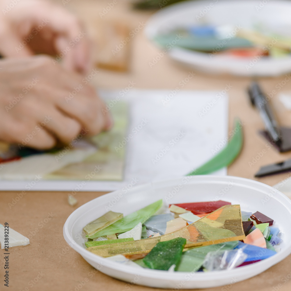 Closeup photo of creative woman making bright mosaic