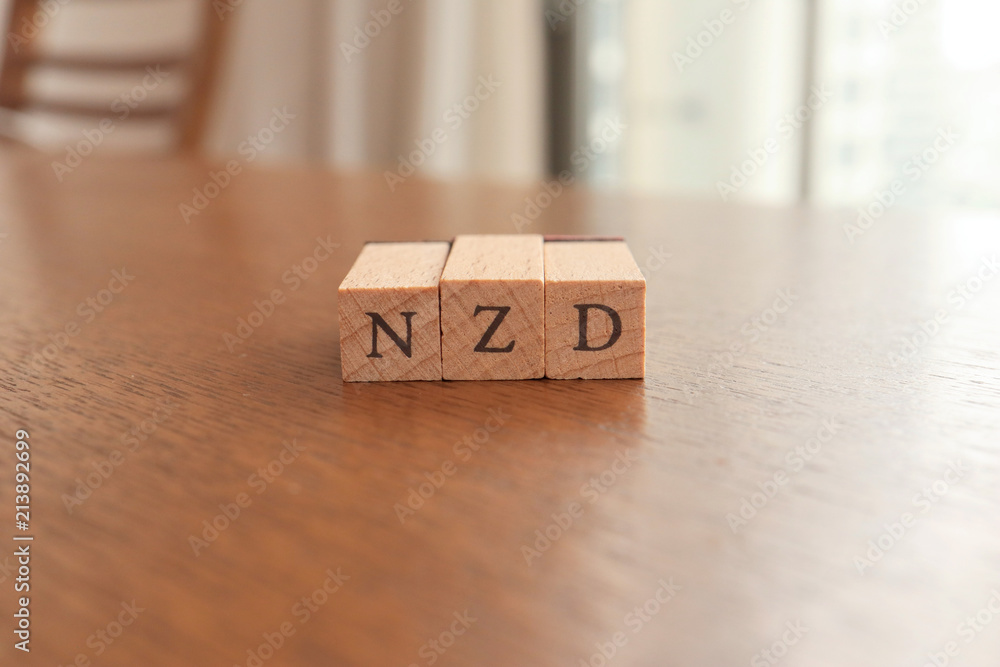 NZD (New Zealand Dollar) Text Block on Wooden Table NZD (New Zealand Dollar) Text Block on Wooden Table