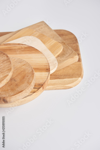 close up shot of stack of different wooden cutting boards on white table