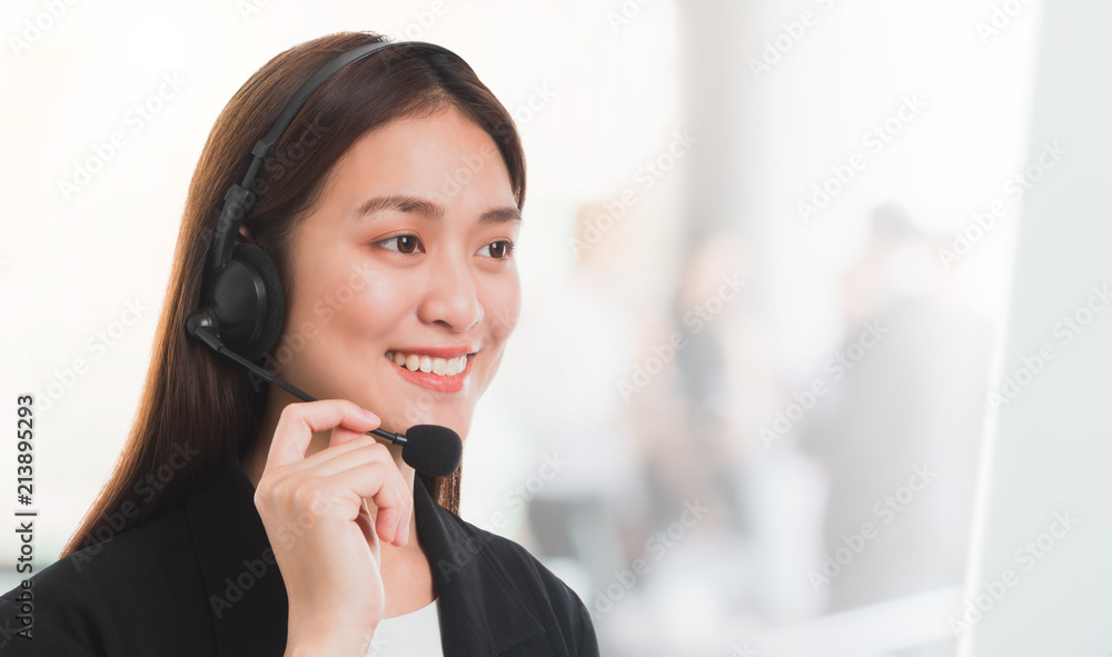 Portrait of Asian beautiful smiling woman customer support phone operator in office space background and copy space.Concept call center job service. Portrait of Asian beautiful smiling woman customer support phone operator in office space background and copy space.Concept call center job service.