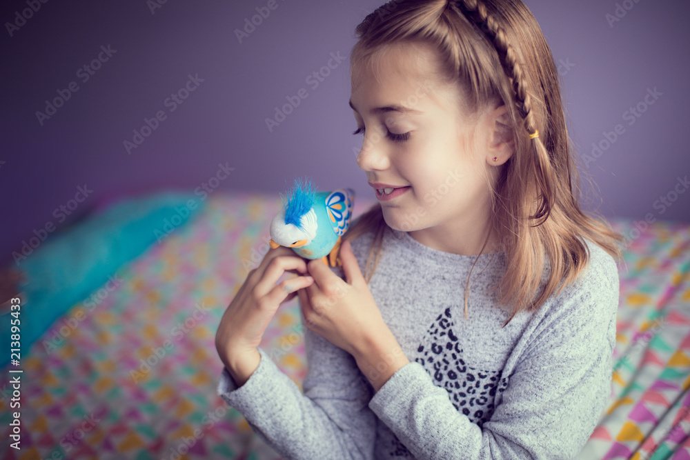 Humorous portrait of little girl with a plastic bird as a pet Humorous portrait of little girl with a plastic bird as a pet