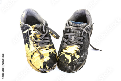 Pair of old paint covered training shoes on a white background photo