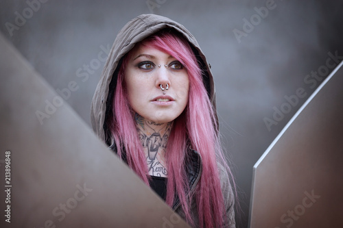 Valokuva young alternative woman with pink hair piercings and tattoos gazing into distanc