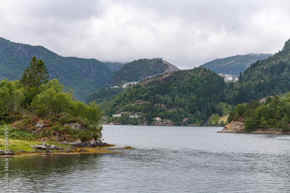 The mountainous shores of the fjord have a complex terrain. Monstraumen, Hordaland country, Norway, Europe.