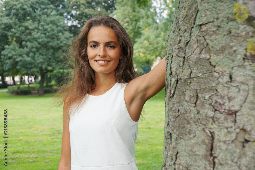 nature loving young woman wearing white dress in a park nature loving young woman wearing white dress in a park