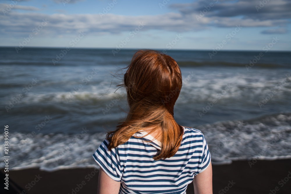 The young girl looking at the sea