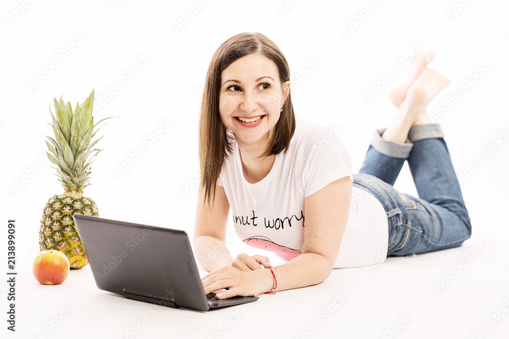 Young woman with computer and fruits laughing, isolated on white background Young woman with computer and fruits laughing, isolated on white background