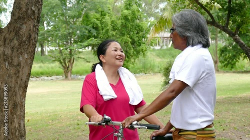 Senior asian couple talking together after finised exercise in park photo