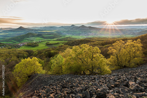 Romantic sunset over rolling hills. View from stony and rocky hill. Fresh green all around. Spring time in the air. © janstria