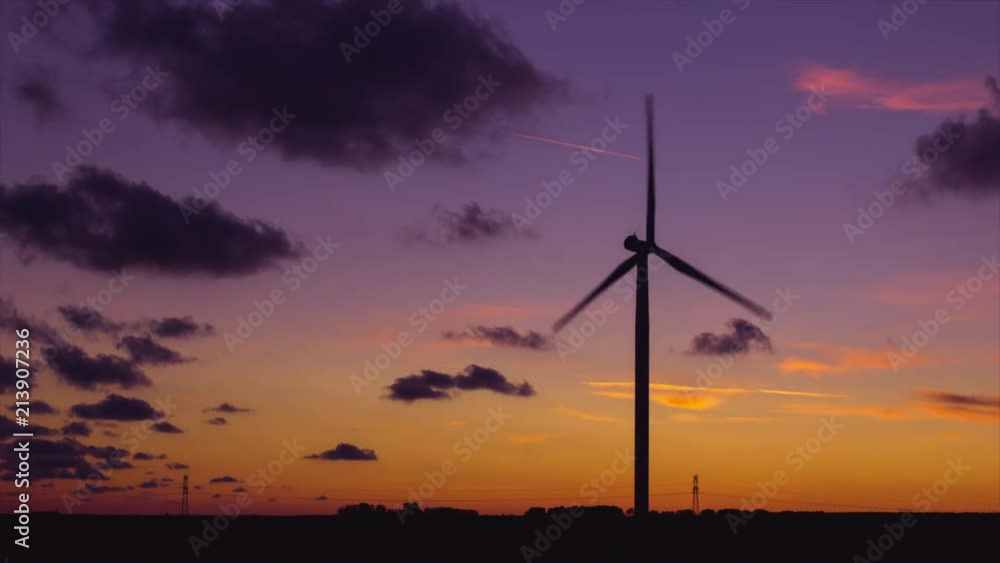 Time lapse of spinning wind turbines for electrical power generation at beautiful sunset with colorful cloudy sky in Normandy, France. Modern technology of environment friendly energy production Time lapse of spinning wind turbines for electrical power generation at beautiful sunset with colorful cloudy sky in Normandy, France. Modern technology of environment friendly energy production