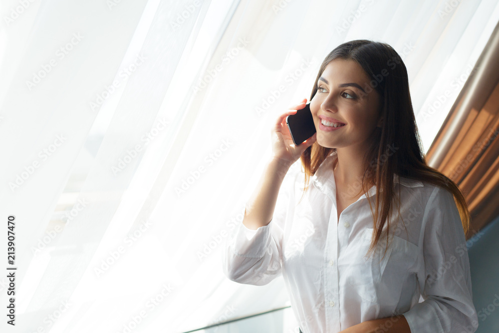 Young business woman talking with phone in the hotel.